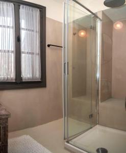 a shower with a glass door in a bathroom at Samos Serenity - Classic Retreat near the beach in Koumeika