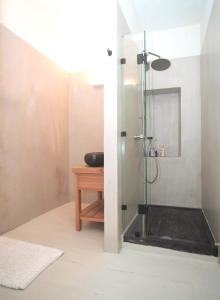 a bathroom with a shower with a wooden table at Samos Serenity - Classic Retreat near the beach in Koumeika