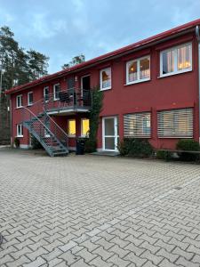 ein rotes Gebäude mit einer Treppe davor in der Unterkunft Apartment Roth in Roth