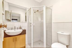 a bathroom with a toilet and a sink and a shower at Bayside Bungalow in Glenelg