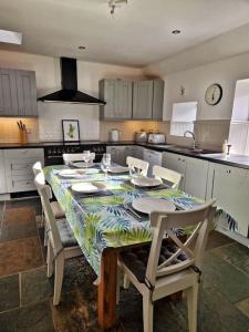 a kitchen with a table with chairs and a kitchen counters at Cullen Seaside Cottage in Cullen