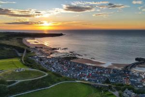 an aerial view of a beach at sunset at Cullen Seaside Cottage in Cullen