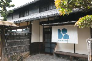 a building with a sign on the side of it at DENIM HOUSE BON in Kurashiki