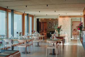 a dining room with tables and chairs and windows at Sternen Bohlingen Aparthotel in Singen