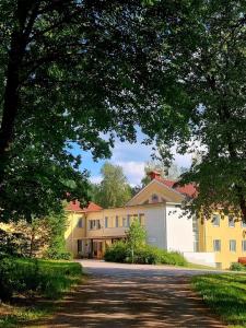 un gran edificio amarillo con una entrada delante de él en EnjoyNature B&B, en Lahti