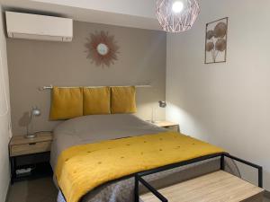 una camera con un letto con una coperta gialla di Bel appartement 4 étoiles Centre Historique Toulon a Tolone