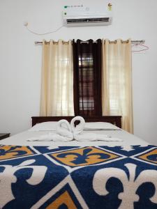 a bed with a blanket with a bow on it at Enna homestay in Varkala