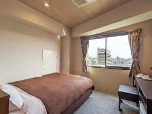 Hotel New Gaea Ube في يوبي: غرفة نوم بسرير كبير ونافذة