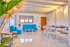 a living room with blue furniture and a table at Èmar Corfu in Arillas