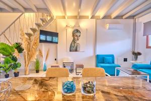 uma sala de estar com uma mesa e cadeiras azuis em Èmar Corfu em Arillas