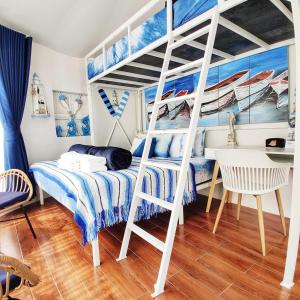 a bedroom with a bunk bed with a ladder at Hello Banchuen Beach in Ban Nong Wiwat