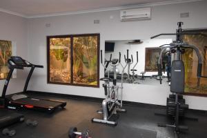 a gym with several treadmills and ellipticals in a room at SHERBOURNE LODGE in Kitwe