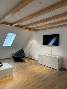 sala de estar con TV de pantalla plana en la pared en Urban Elegance Maisonette Selb en Selb