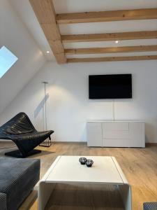 sala de estar con sofá y TV en la pared en Urban Elegance Maisonette Selb en Selb