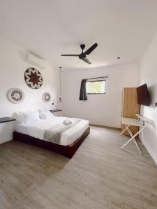 a bedroom with a bed and a ceiling fan at The Confidential Mandalika in Kuta Lombok