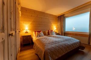 um quarto com uma cama e uma grande janela em Fresh & Simple near Gstaad em Gstaad
