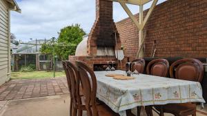 a table and chairs with a fireplace in a backyard at Learmonth Guesthouse - Queenscliff in Queenscliff