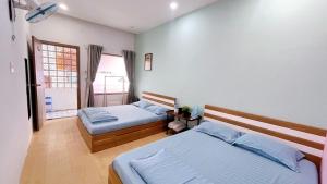 um quarto com 2 camas e uma janela em Little Quy Nhơn Homestay em Quy Nhon