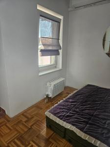 - une chambre avec un lit et une fenêtre dans l'établissement Apartman Ellye, à Lukavica