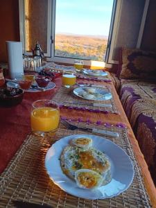 un tavolo con piatti di cibo e bicchieri di succo d'arancia di café restaurant Bivouac relax 