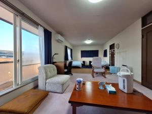 a living room with a couch and a table at guesthouse ONAKA in Mimase