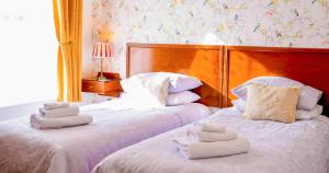 two beds with towels on them in a bedroom at Grange Bank House in Shanklin