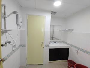 ein weißes Badezimmer mit einem Waschbecken und einem Spiegel in der Unterkunft Luxpro Beachfront Homes Port Dickson in Port Dickson