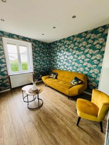 - un salon avec un canapé jaune et une table dans l'établissement Petite Demeure, à Paray-le-Monial