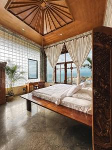 a bedroom with a large bed with a large window at Uluwatu Mansion Villas in Uluwatu