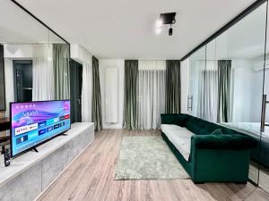 ein Wohnzimmer mit einem grünen Sofa und einem TV in der Unterkunft CozyBoutique @subway in North in Pipera