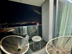 ein Balkon mit zwei Stühlen und Blick auf die Stadt in der Unterkunft CozyBoutique @subway in North in Pipera