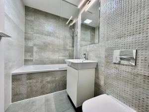 ein Badezimmer mit Waschbecken, Toilette und Badewanne in der Unterkunft CozyBoutique @subway in North in Pipera + 2 Fotos