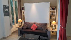 - un salon avec un canapé et un oreiller rouge dans l'établissement Charmant studio tout proche du port, à Nice