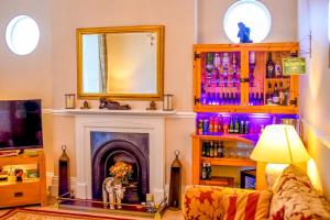 a living room with a fireplace and a mirror at Grange Bank House in Shanklin