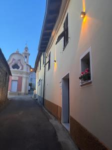 un callejón con un edificio con una ventana y una torre de reloj en Á Ćà de Matilde en Ranzo-Borgo