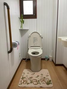 a small bathroom with a toilet with the lid up at Shinshulanson in Nagano
