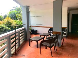 a patio with chairs and tables on a balcony at Badladz Staycation Condos in Puerto Galera