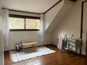 Zimmer im Dachgeschoss mit einem Tisch und einem Fenster in der Unterkunft Shinshulanson in Nagano