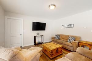 a living room with two couches and a flat screen tv at Peakes Peace - B in Dedham