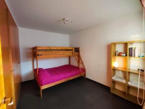 a small bedroom with a bunk bed with purple sheets at Ca La Perla in Albalat de Taronchers