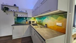 a kitchen with a sink and a colorful wall at Menta Holiday Home in Badacsonytomaj