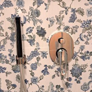 a toilet paper holder on a wall with floral wallpaper at Al 68 Di Piazza Cavour in Naples