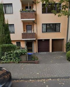 ein Apartmenthaus mit zwei Garagentüren und einer Auffahrt in der Unterkunft The Nano Pad - small, smart, central in Köln