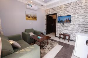 a living room with a couch and a brick wall at Taraf Al Asalah Villas in An Nimāş