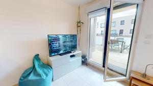 een woonkamer met een tv en een groot raam bij CityHeart Constellation avec parking in Straatsburg