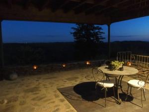 a table and chairs on a patio at night at Louradou-sur-Ciel in Jouqueviel