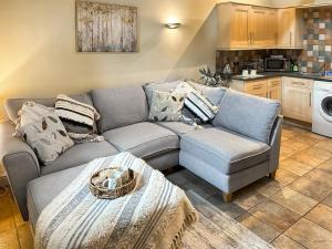 uma sala de estar com um sofá e uma mesa em Damsels Bower em Bakewell
