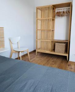 a bedroom with a bed and a chair and a book shelf at Apartament Foka - Rowy in Rowy