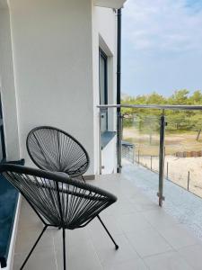 a black chair sitting on a balcony with a view at Apartament Foka - Rowy in Rowy