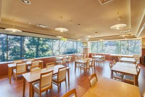 a restaurant with tables and chairs and large windows at Shiki Resort Villa Hakone 80 in Hakone